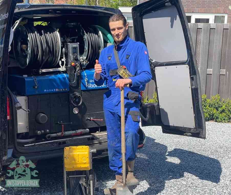 Een tevreden monteur met opgestoken duim naast de bestelbus, slim ingrijpen bespaart kosten bij een verstopte afvoer in Bergen