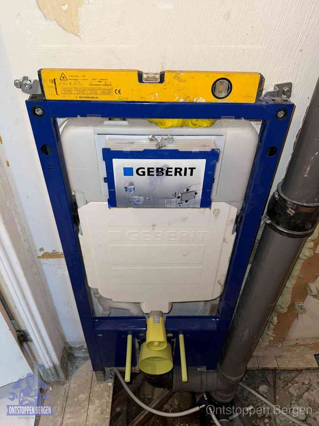Een Geberit inbouwreservoir met frame voor een hangtoilet tegen de wand, met de afvoerbocht naar de vloer, kenmerkend voor een verstopt hangtoilet in Bergen