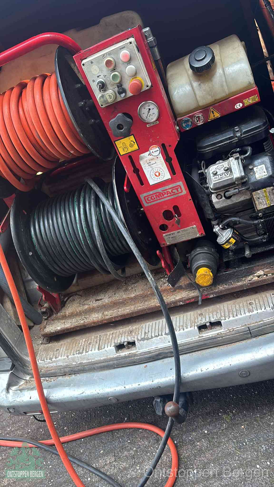 Een rood hogedruk-rioolreinigingstoestel in de laadbak van de bedrijfsbus, apparatuur voor een hardnekkige afvoerverstopping in Bergen