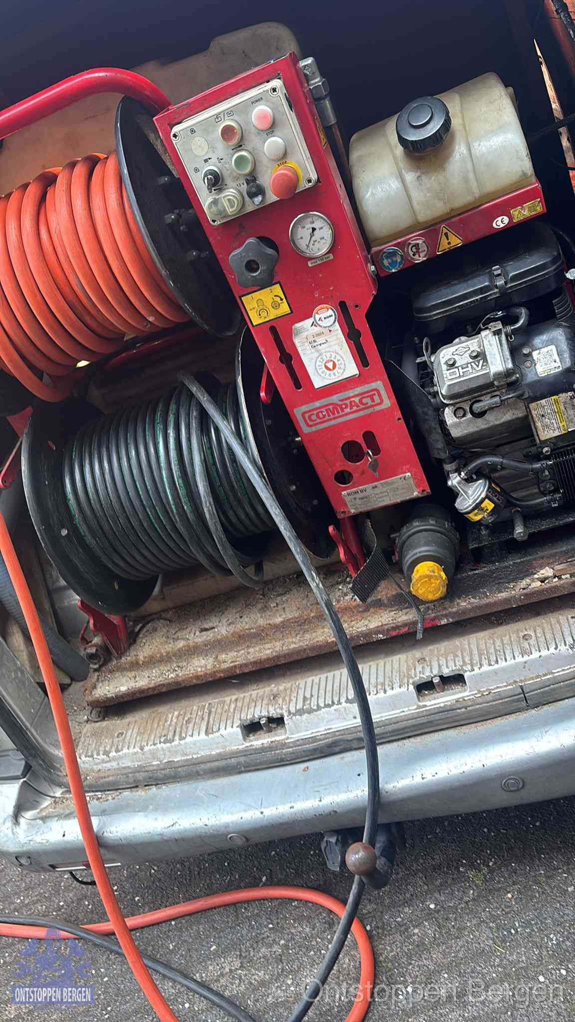 Een rood hogedruk-rioolreinigingstoestel met slangen in de laadbak van de bedrijfsbus, apparatuur voor een hardnekkige wc-verstopping in Bergen