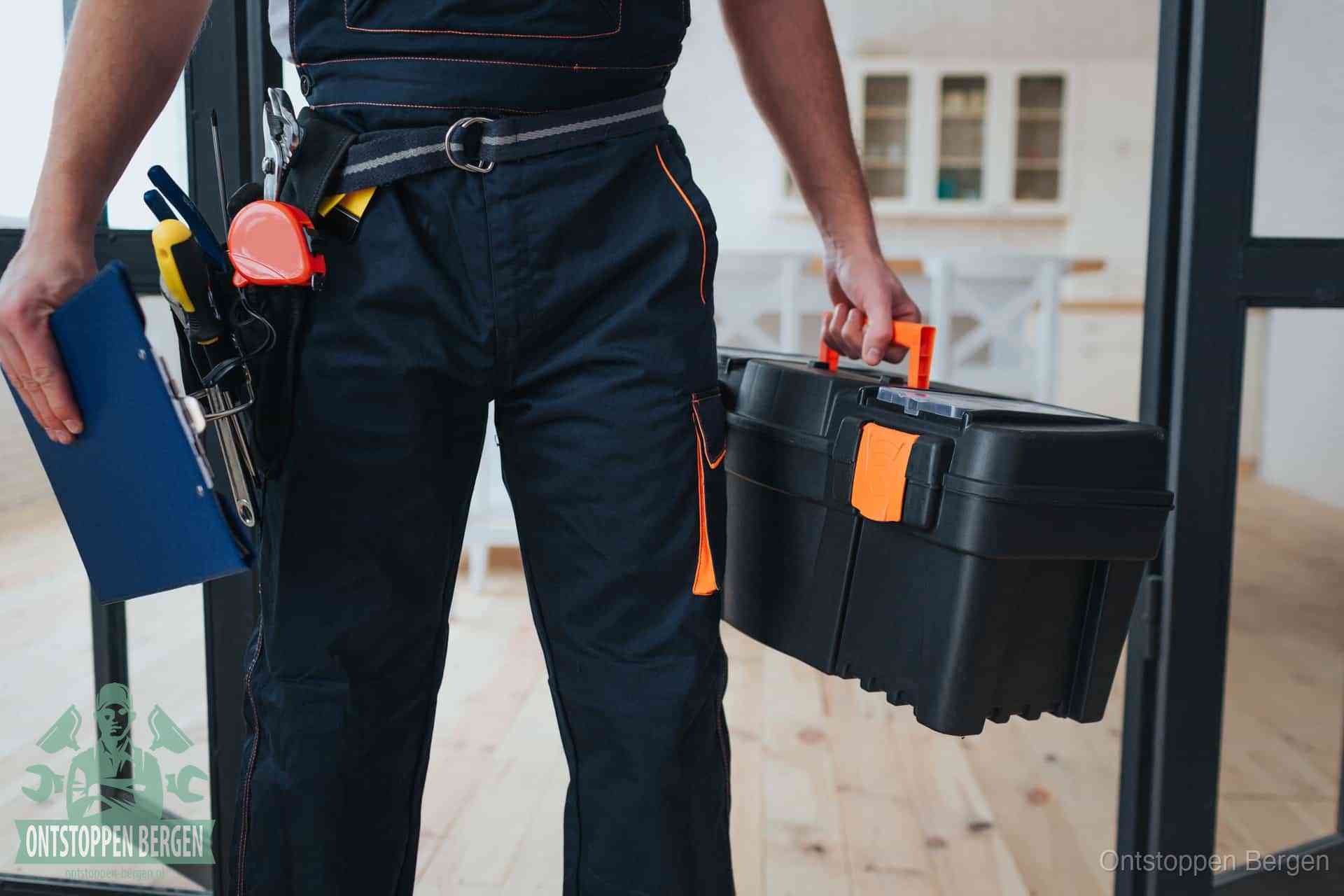Een monteur met gereedschapsriem en klembord, klaar om een transparante prijs voor het afvoer ontstoppen in Bergen te geven