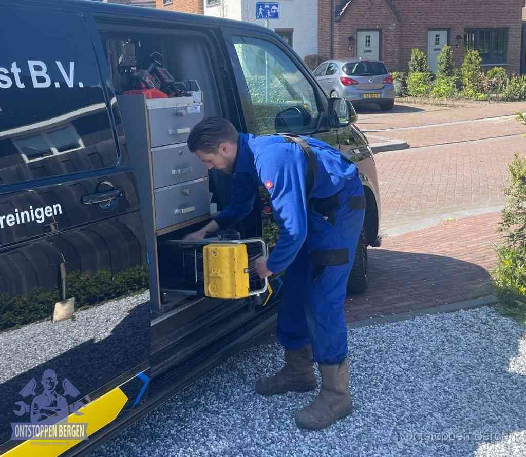 Een monteur pakt apparatuur uit de bedrijfsbus voor service aan huis, het moment om een professional in te schakelen voor een verstopte wc in Bergen